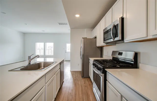 a kitchen that has a sink and a stove top oven