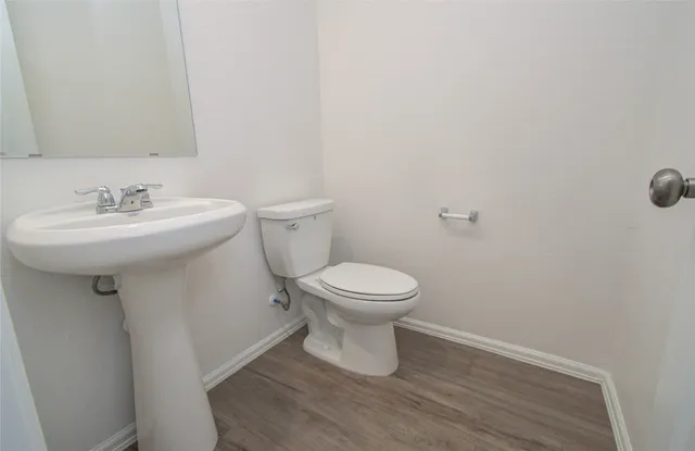 a bathroom with a sink toilet and a mirror