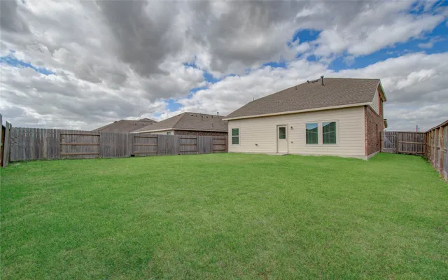 a view of a house with a big yard and a large tree