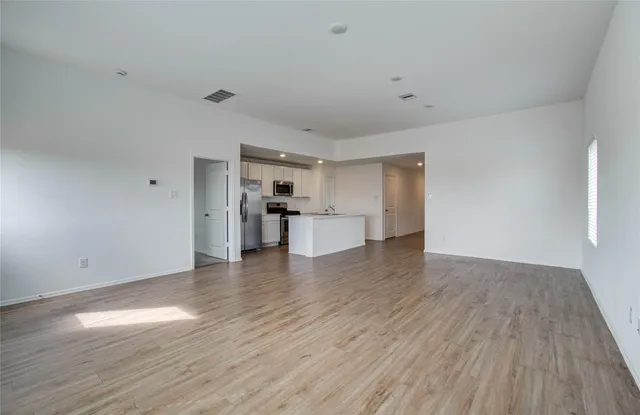a view of a kitchen with wooden floor and a refrigerator