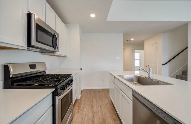 a kitchen that has a sink and a stove top oven