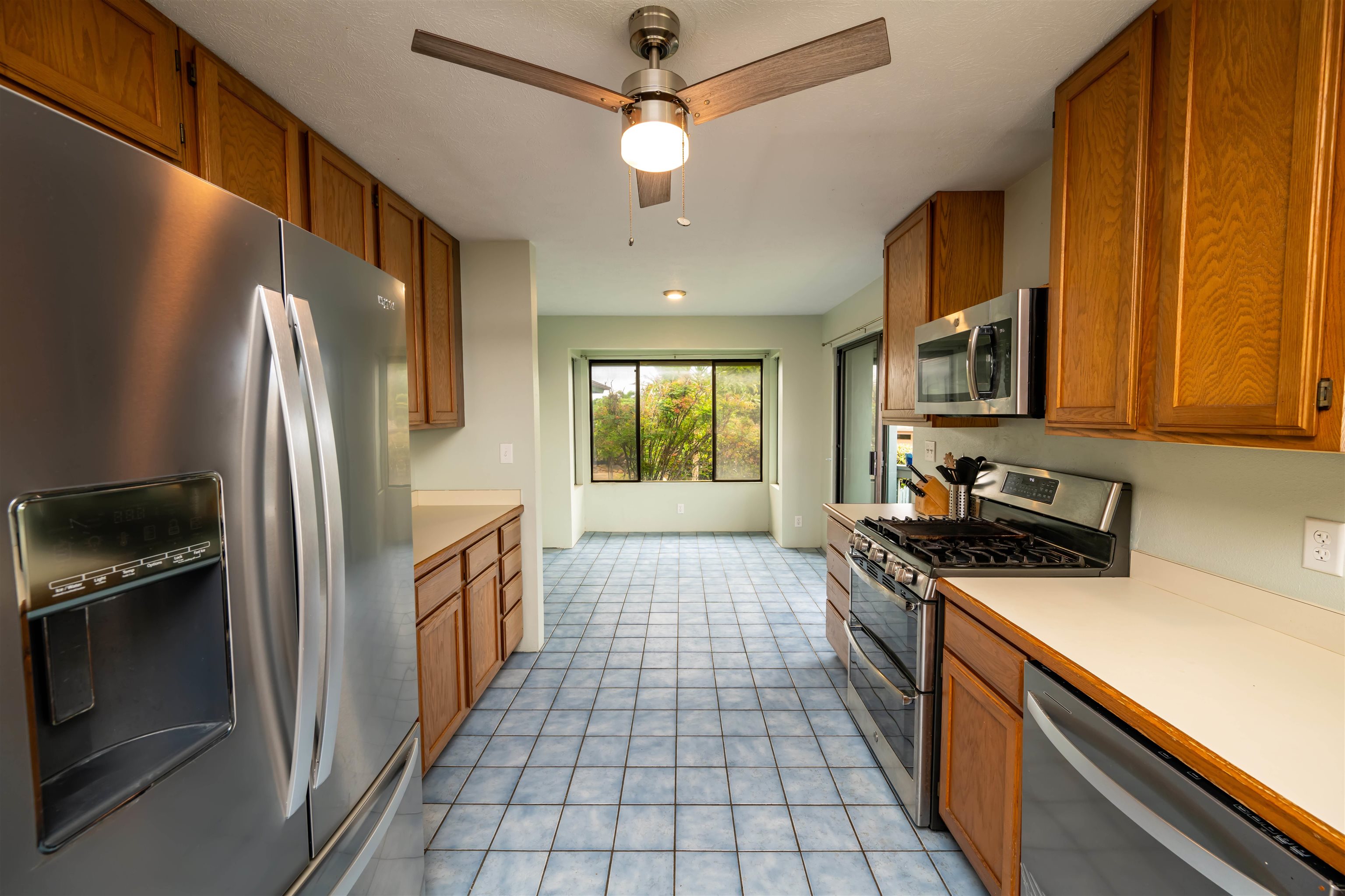 657 Mapuana Place Wailuku, HI 96793 - Photo 4 of 30 a kitchen with stainless steel appliances granite countertop a refrigerator a stove top oven a sink and dishwasher
