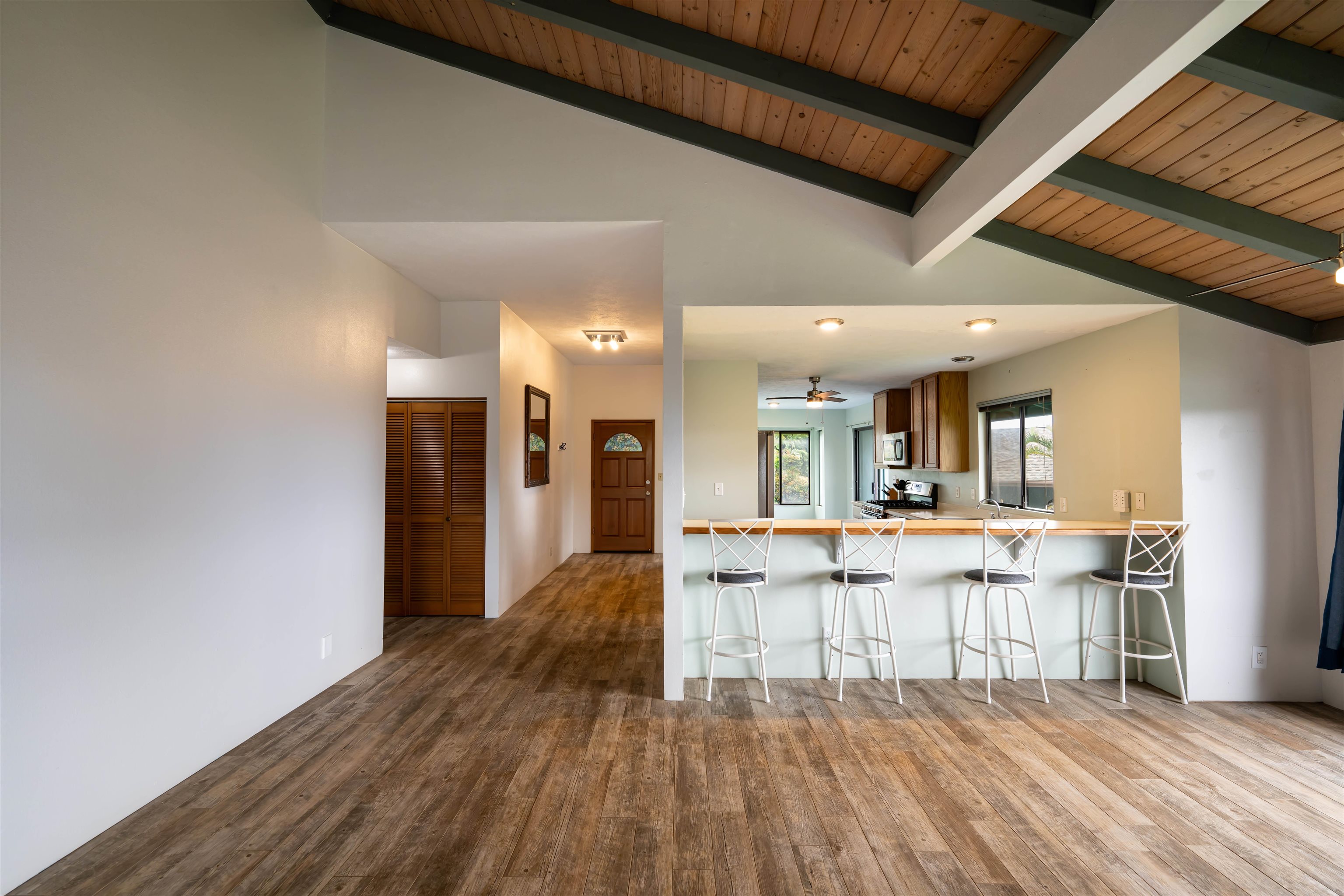 657 Mapuana Place Wailuku, HI 96793 - Photo 7 of 30 a large white kitchen with wooden floor and stainless steel appliances