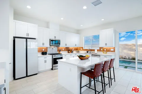 a large kitchen with a stove top oven a sink a counter space and cabinets