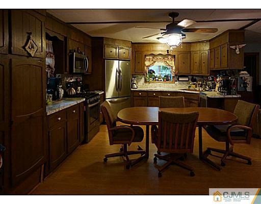 59 Utica Road Edison, NJ 08820 - Photo 2 of 6 a kitchen with stainless steel appliances granite countertop table chairs microwave and sink