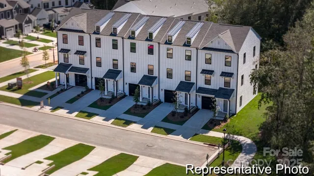a view of a patio with couches and table potted plants and large tree