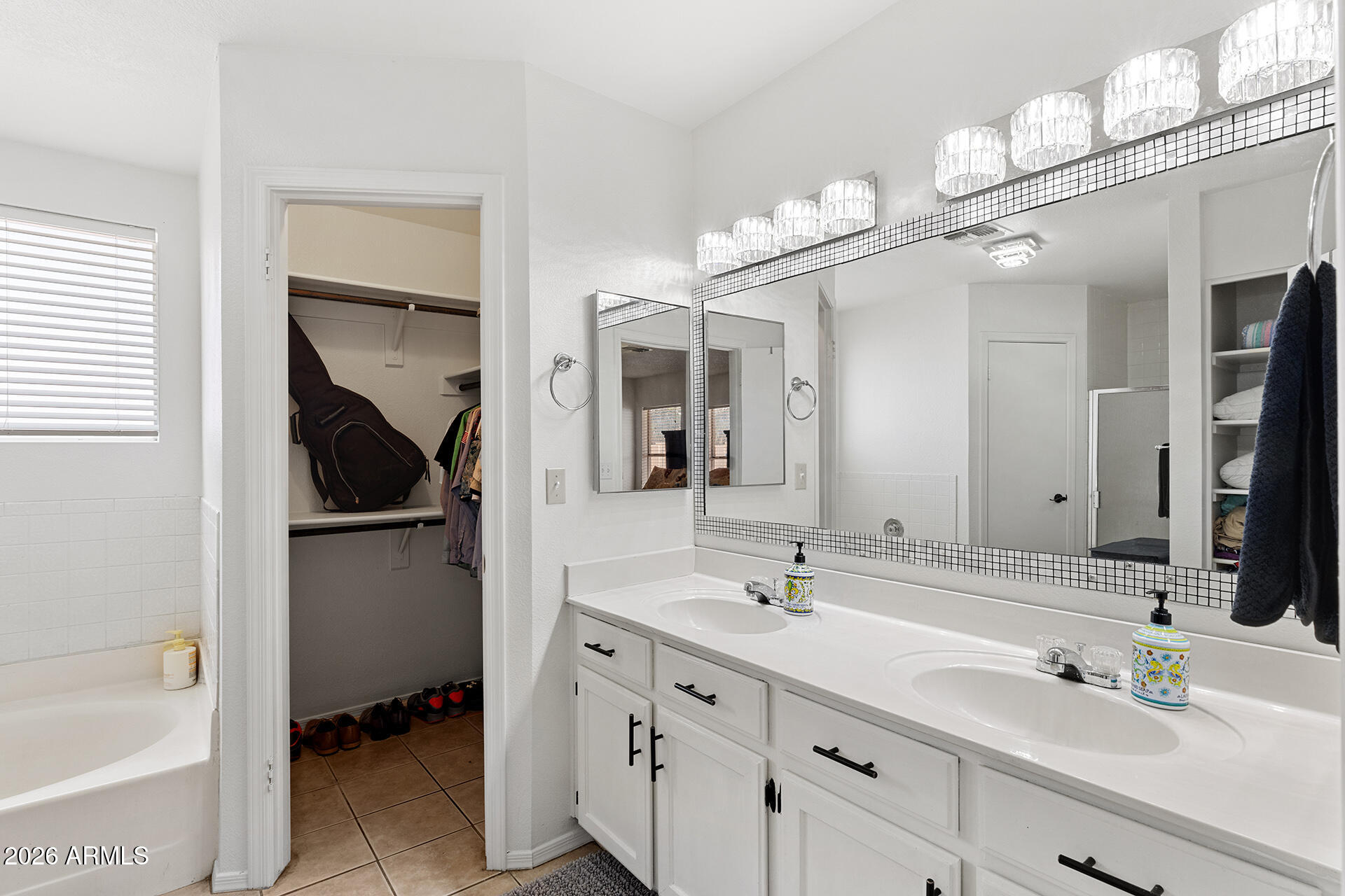 9002 West Coronado Road Phoenix, AZ 85037 - Photo 34 of 54 a bathroom with a double vanity sink a mirror a bathtub and
