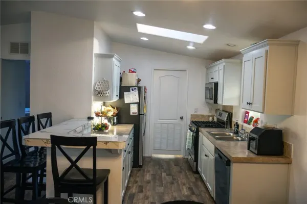 a kitchen that has a dining table cabinets and appliances