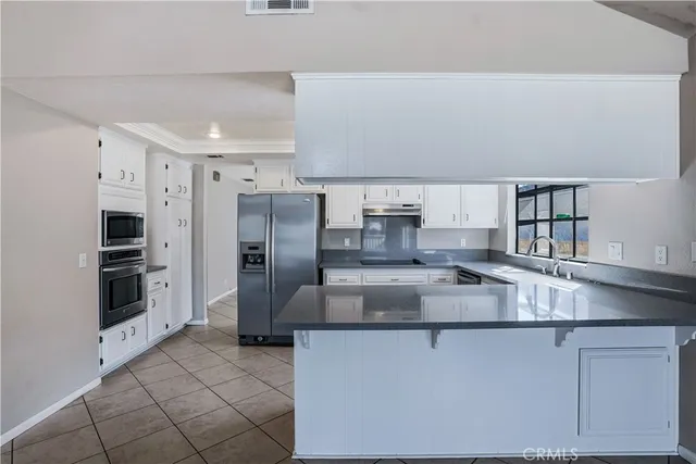 a kitchen with stainless steel appliances granite countertop a refrigerator and a stove