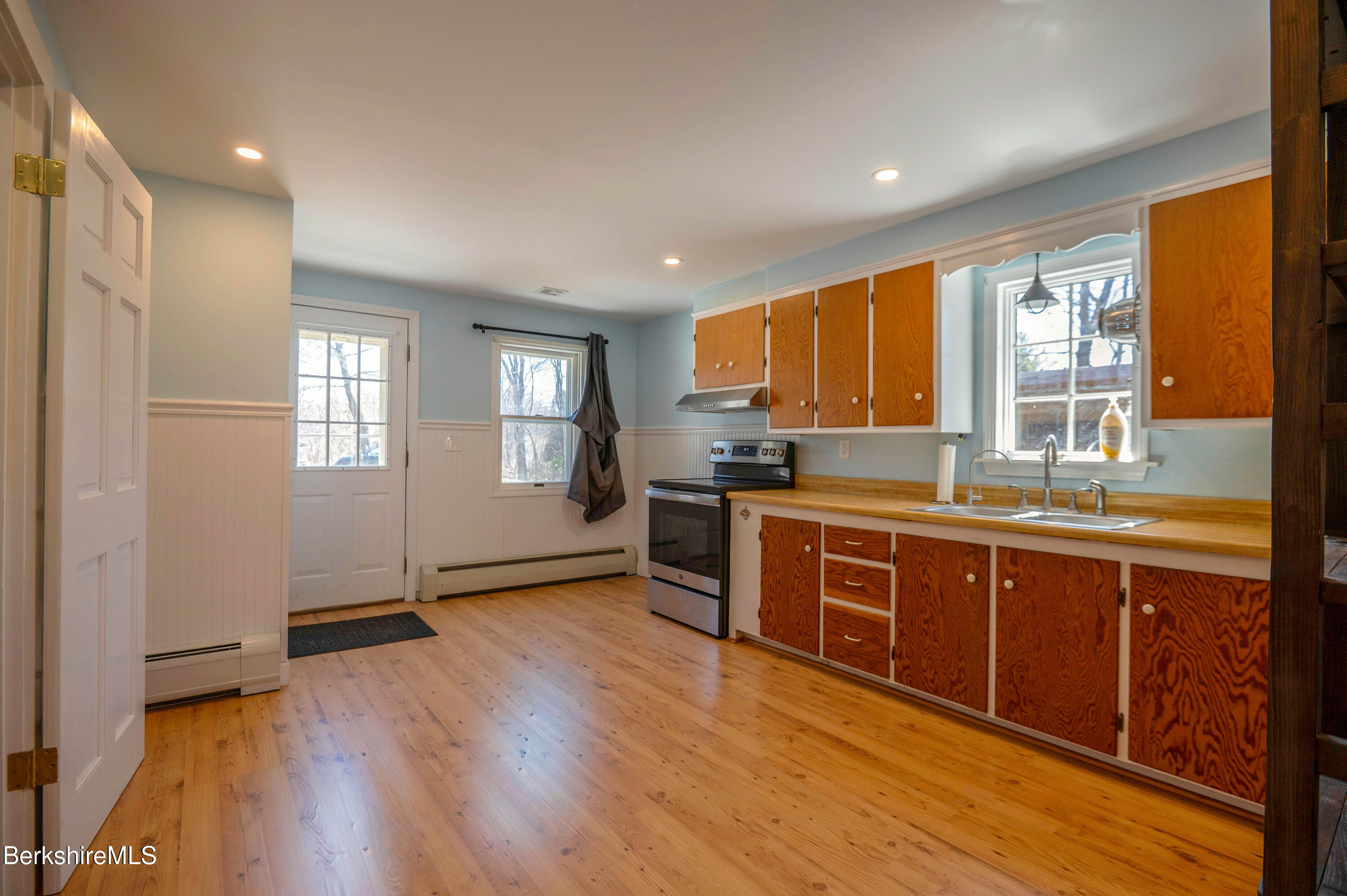 28 Adell Street Pittsfield, MA 01201 - Photo 12 of 26 a large kitchen with stainless steel appliances granite countertop a refrigerator a sink dishwasher a stove and white countertops with wooden floor