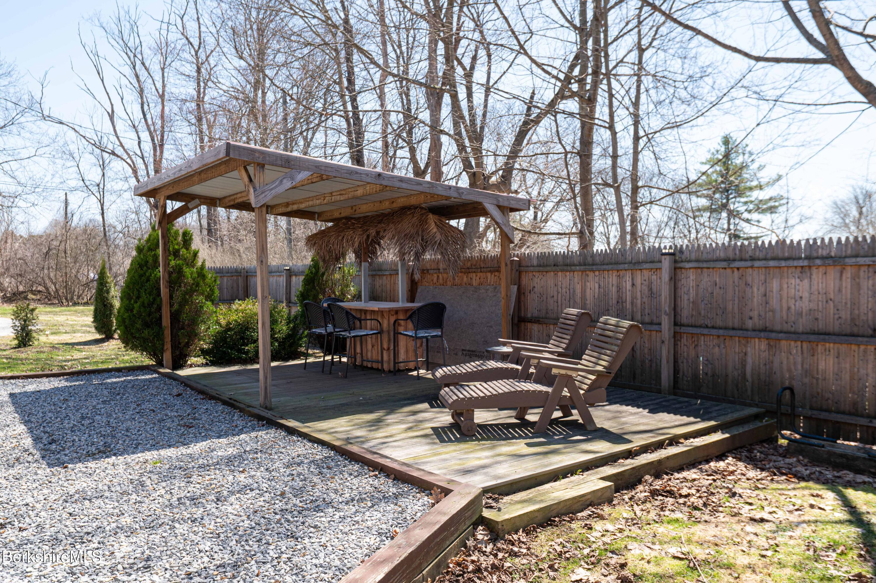 28 Adell Street Pittsfield, MA 01201 - Photo 8 of 26 a view of a backyard with table and chairs under an umbrella with large trees