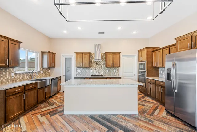 a large kitchen with stainless steel appliances and large counter top