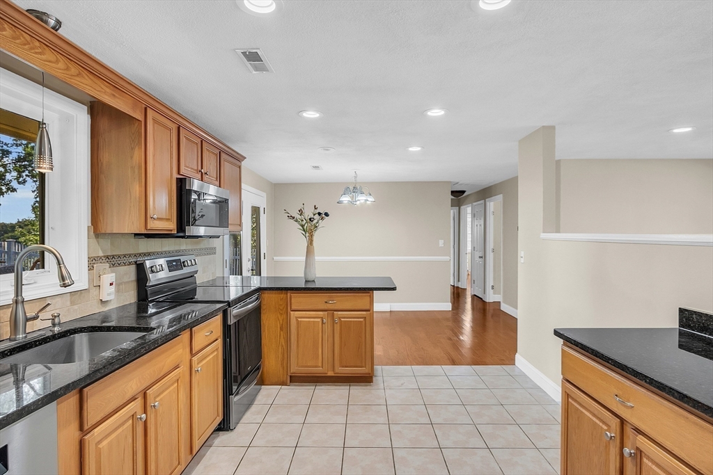 1 Alan Road Hudson, MA 01749 - Photo 11 of 38 a large kitchen with granite countertop a sink and cabinets