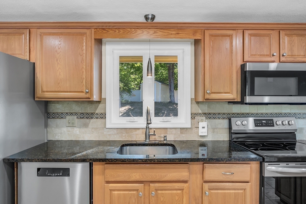 1 Alan Road Hudson, MA 01749 - Photo 13 of 38 a kitchen with granite countertop a stove a sink and a microwave