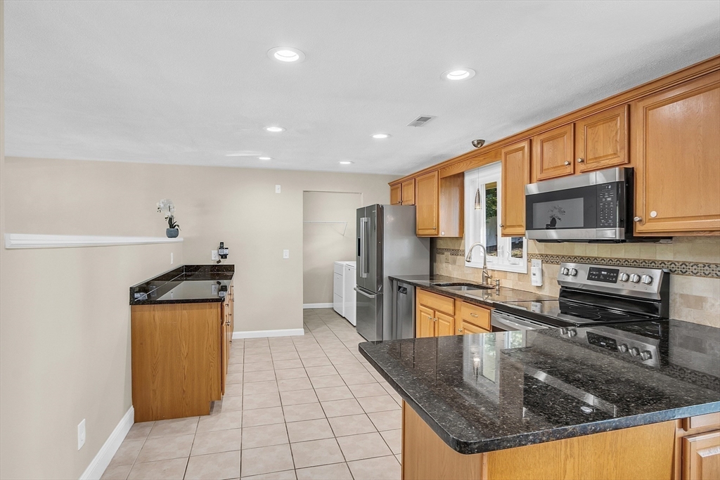 1 Alan Road Hudson, MA 01749 - Photo 14 of 38 a kitchen with stainless steel appliances granite countertop a sink a stove and a refrigerator