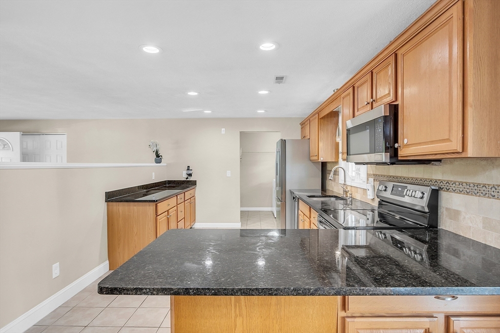 1 Alan Road Hudson, MA 01749 - Photo 15 of 38 a kitchen with stainless steel appliances granite countertop a sink a stove and a refrigerator