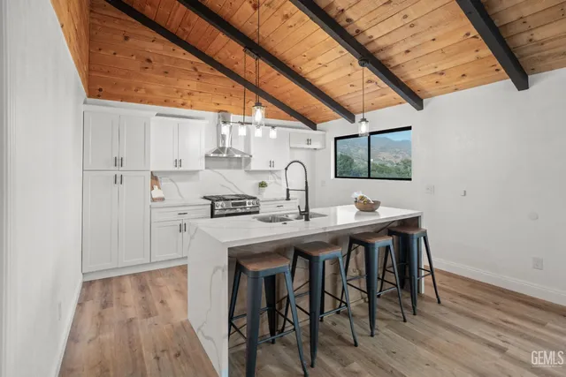 a kitchen with stainless steel appliances a stove and white cabinets