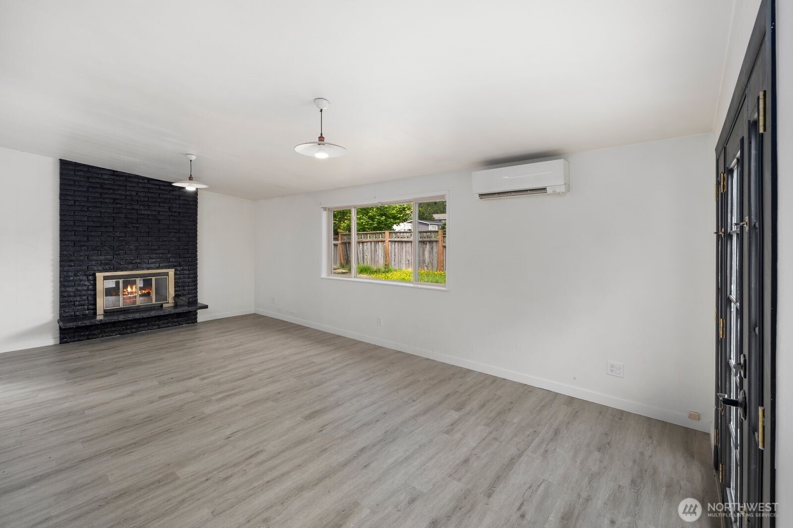 101 161st Street Southeast Bothell, WA 98012 - Photo 20 of 34 an empty room with windows fireplace and wooden floor