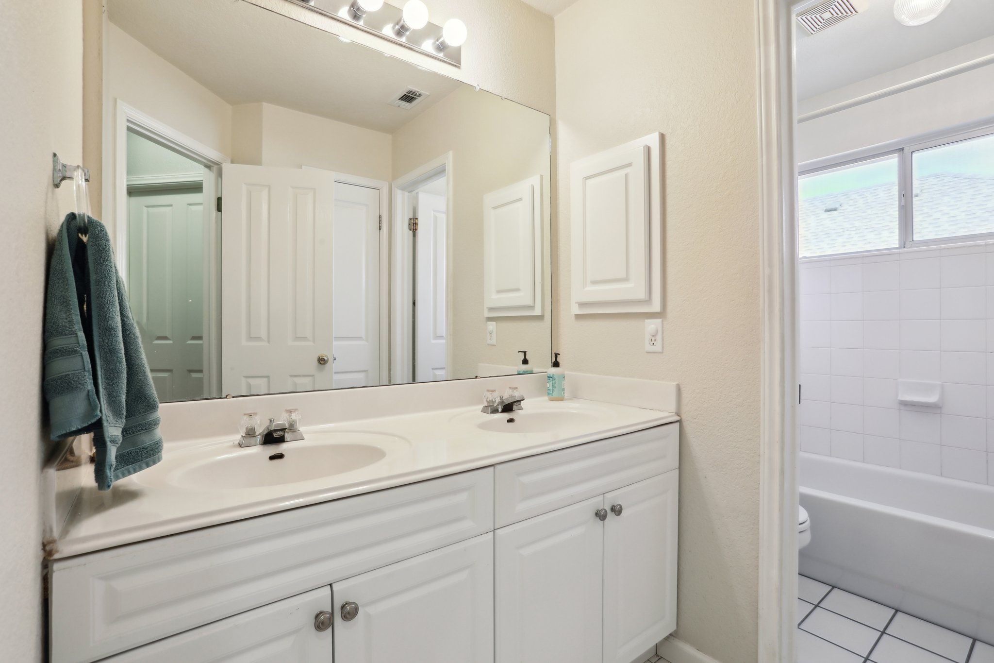 13541 Anarosa Loop Austin, TX 78727 - Photo 22 of 27 Double vanity with white cabinetry and integrated sinks