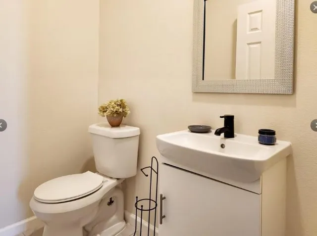 a bathroom with a toilet sink and mirror