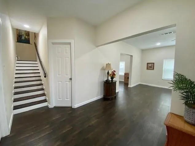 a view of entryway and hall with wooden floor