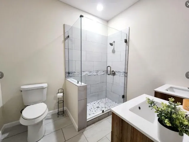 a bathroom with a sink a toilet and shower