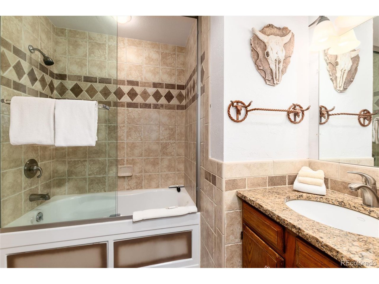 490 Kings Crossing Road, Unit 631 Winter Park, CO 80482 - Photo 25 of 43 a bathroom with a granite countertop sink a mirror and a shower