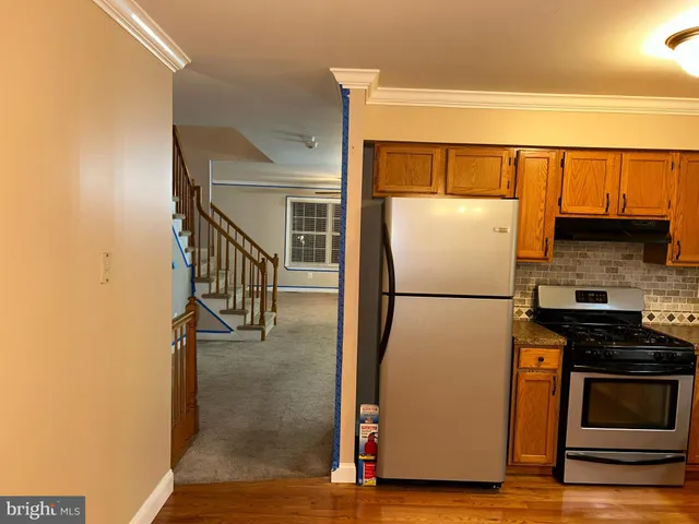 a white refrigerator freezer and a stove sitting inside of a kitchen