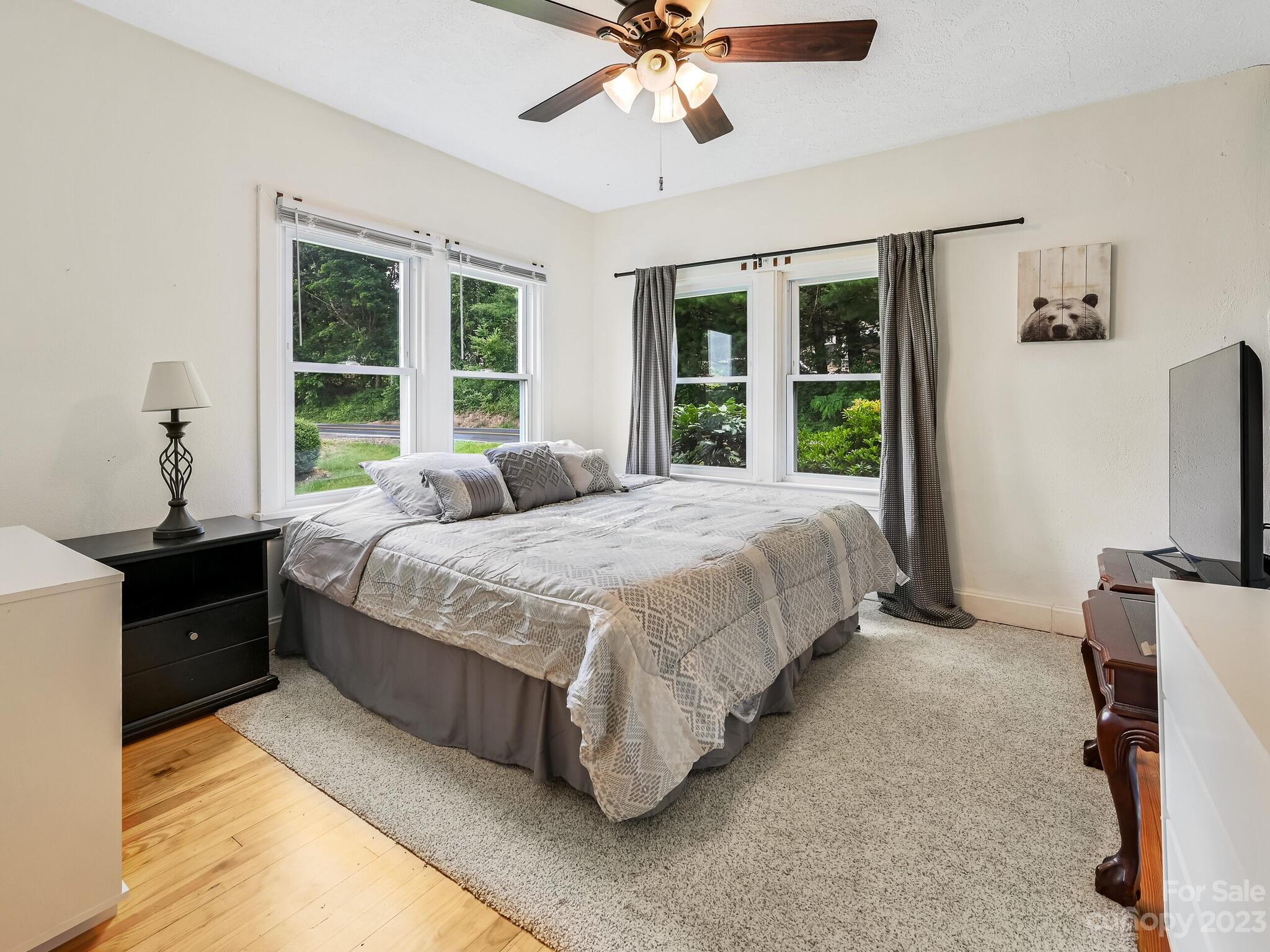 215 Erwin Hills Road Asheville, NC 28806 - Photo 12 of 32 a spacious bedroom with a bed and a chandelier