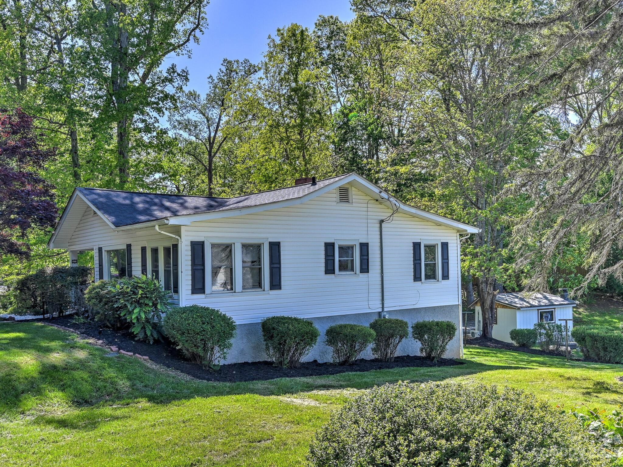 215 Erwin Hills Road Asheville, NC 28806 - Photo 25 of 32 a front view of a house with a yard and potted plants