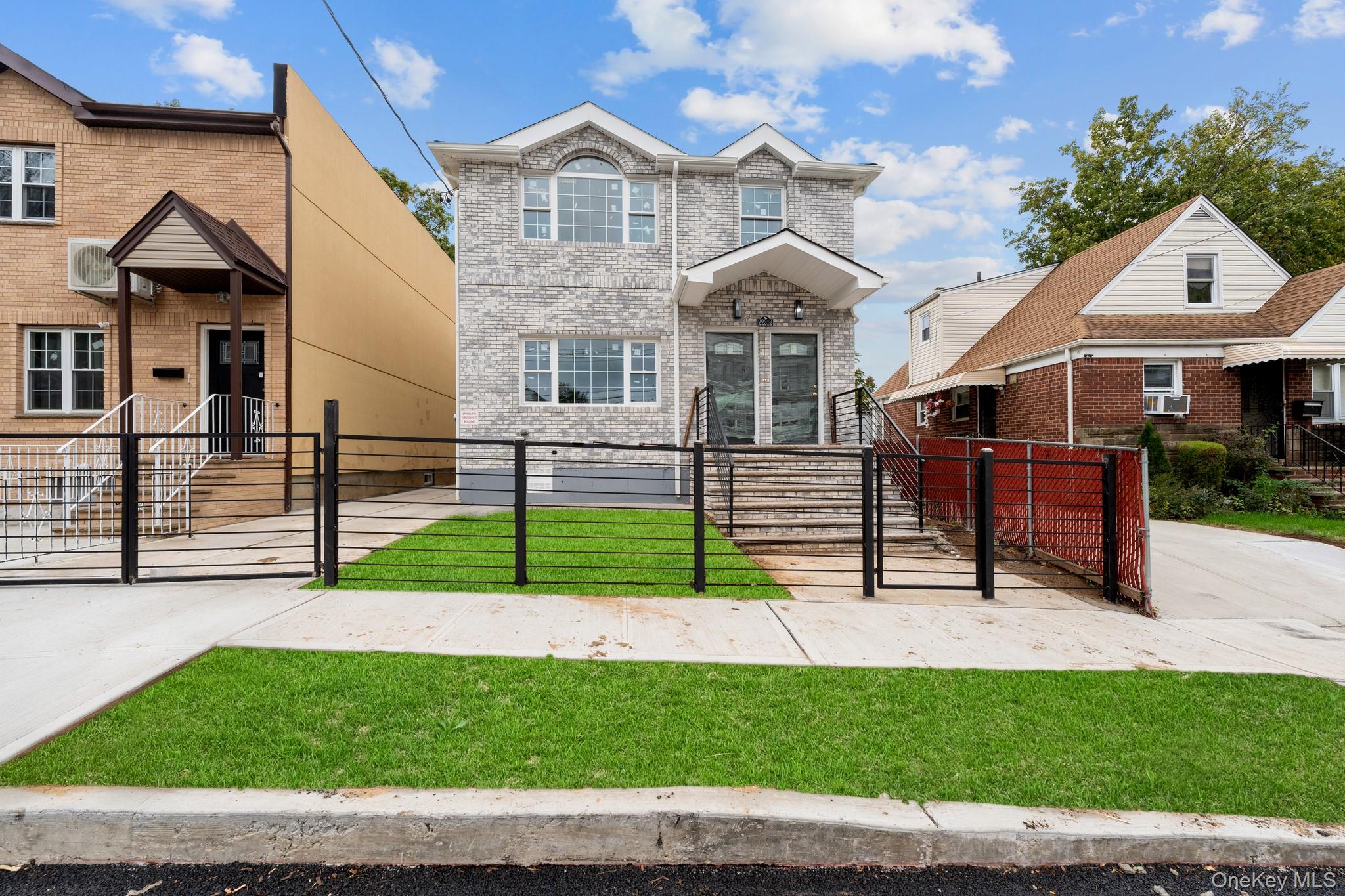 223-12 134th Road Queens, NY 11413 - Photo 16 of 17 View of front of home featuring a gate, brick siding, and a fenced front yard