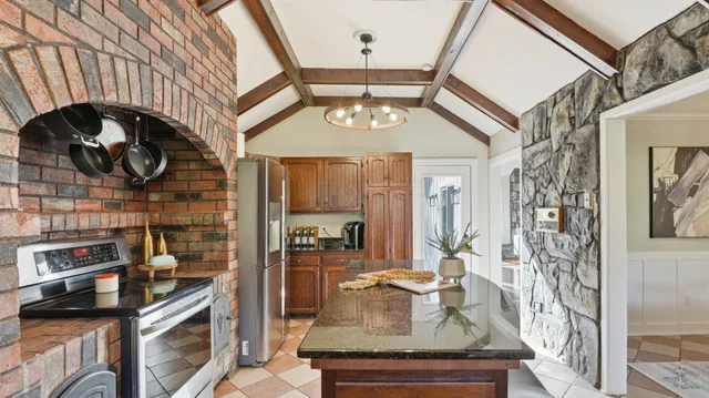 a kitchen with granite countertop white cabinets and refrigerator