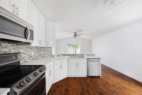 a kitchen with granite countertop a refrigerator stove and sink