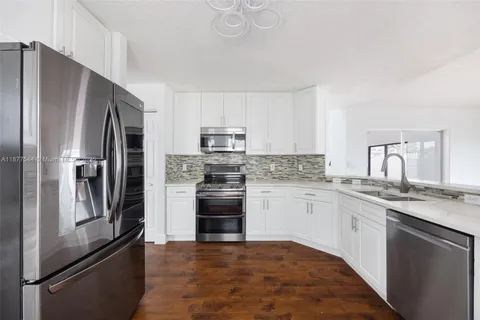a kitchen with granite countertop stainless steel appliances and wooden cabinets