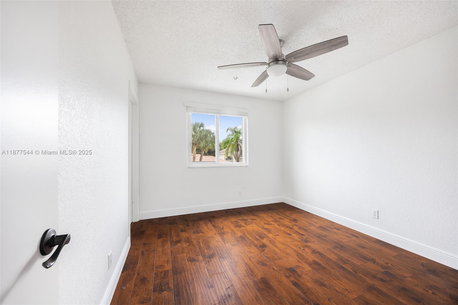 8317 Bermuda Sound Way Boynton Beach, FL 33436 - Photo 19 of 25 an empty room with wooden floor ceiling fan and windows
