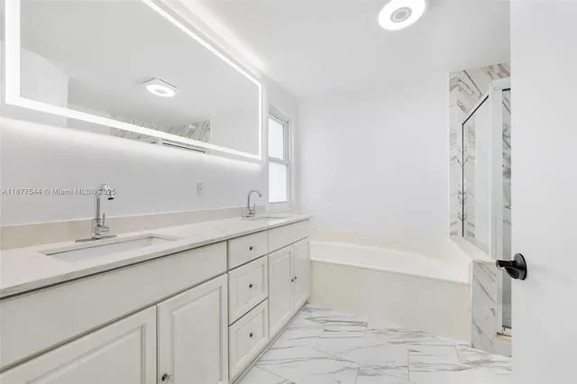 a bathroom with a granite countertop sink toilet mirror vanity and shower
