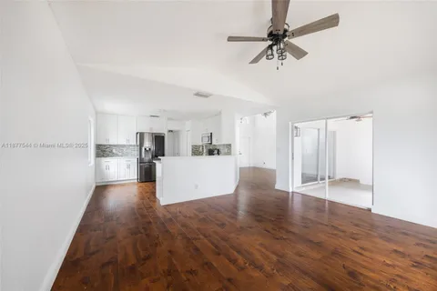 a kitchen with stainless steel appliances a sink a stove a microwave and wooden floor