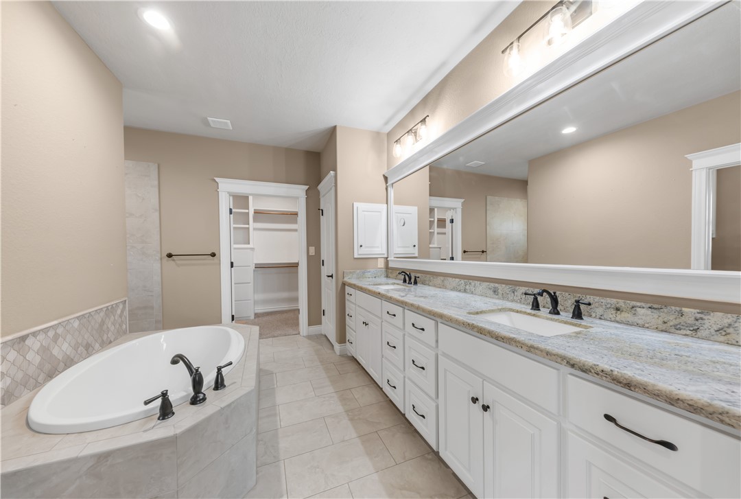 3520 Foxcroft Path Bryan, TX 77808 - Photo 13 of 28 Full bathroom with double vanity, a garden tub, a walk in closet, recessed lighting, and light tile patterned floors