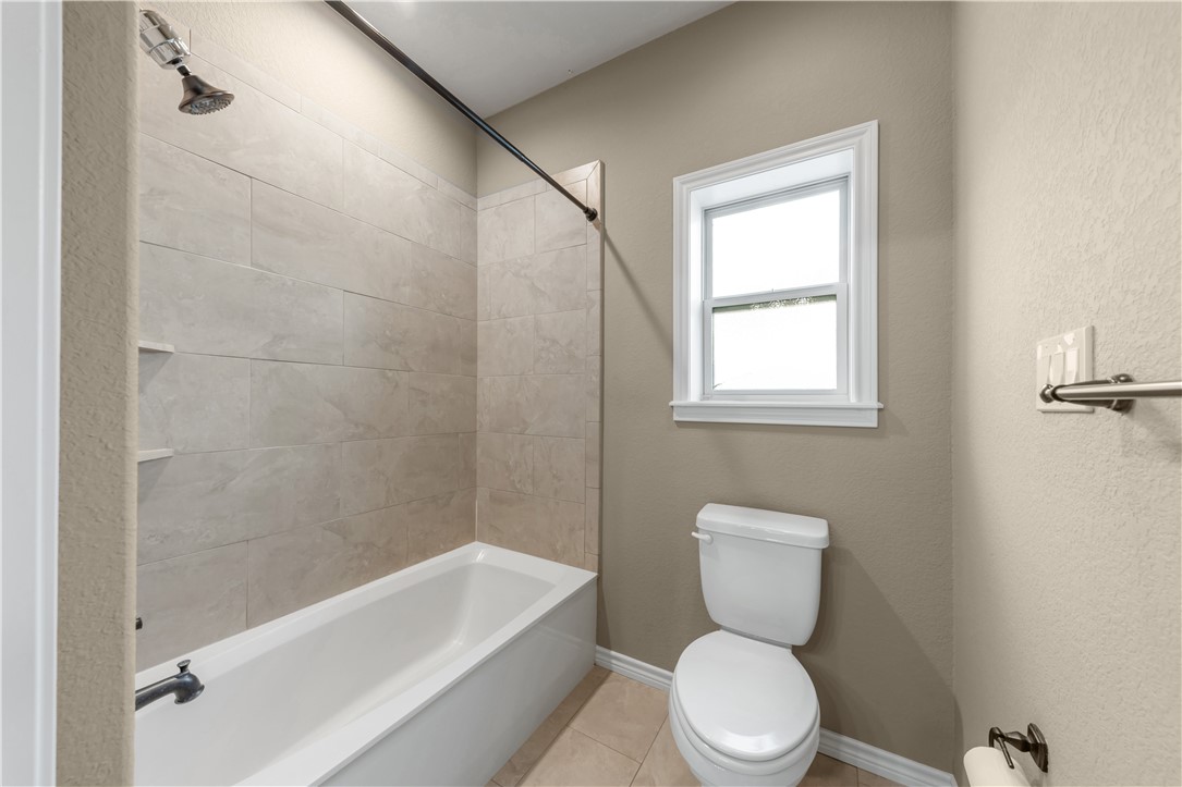 3520 Foxcroft Path Bryan, TX 77808 - Photo 18 of 28 Full bathroom with tub / shower combination, tile patterned floors, and a textured wall