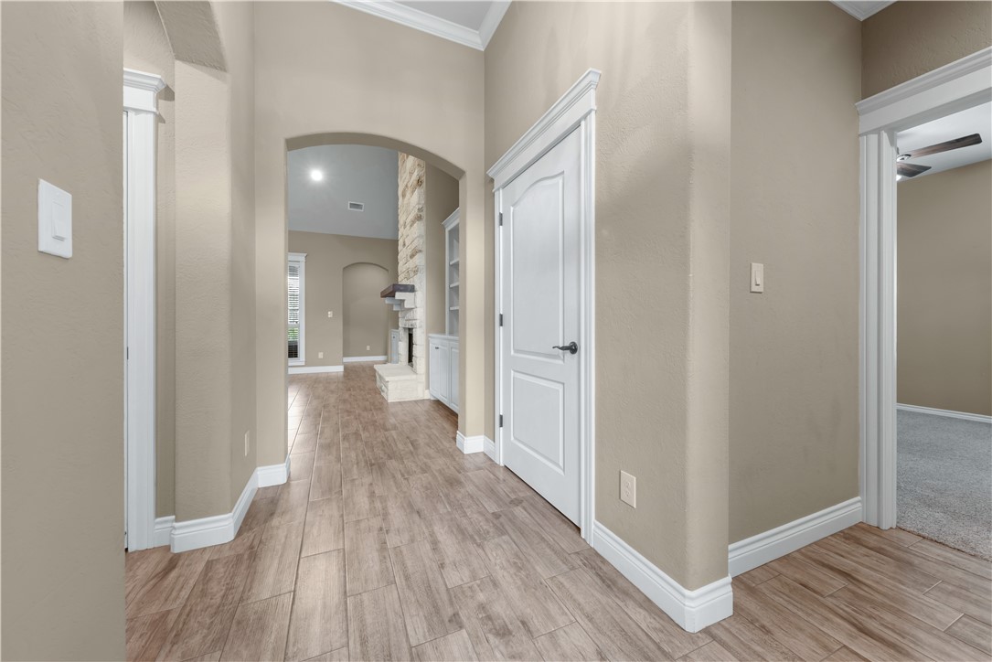 3520 Foxcroft Path Bryan, TX 77808 - Photo 20 of 28 Corridor with arched walkways, light wood-type flooring, and ornamental molding