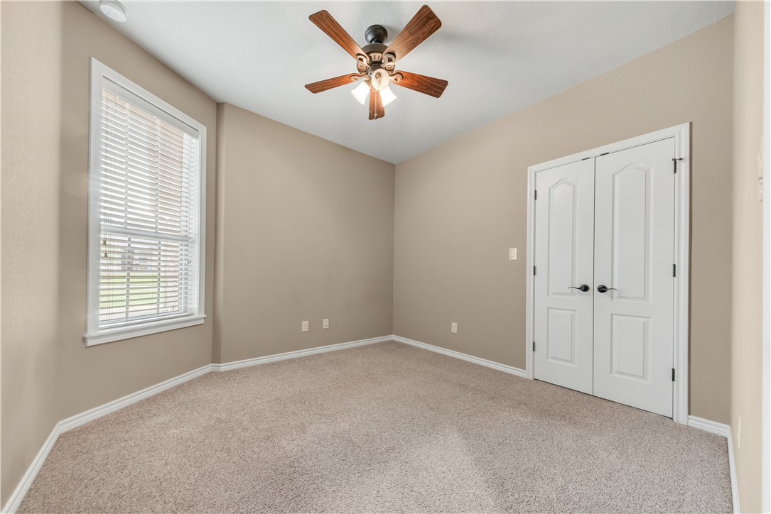 3520 Foxcroft Path Bryan, TX 77808 - Photo 21 of 28 Unfurnished bedroom featuring light colored carpet, multiple windows, a ceiling fan, and a closet