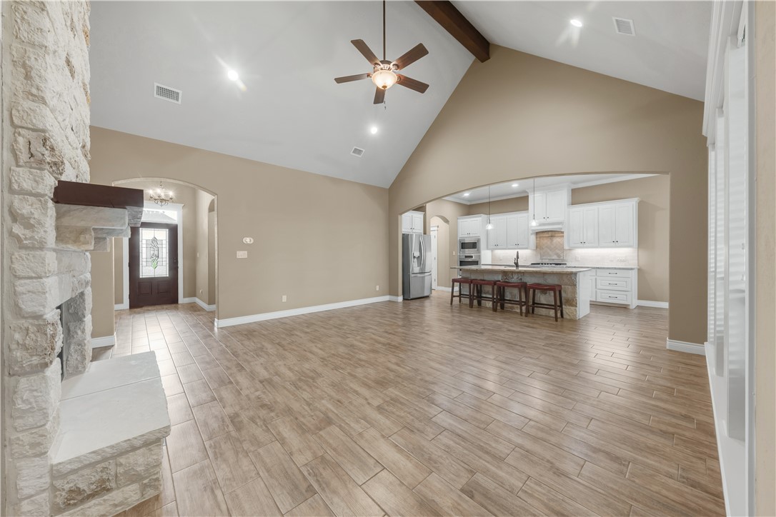 3520 Foxcroft Path Bryan, TX 77808 - Photo 6 of 28 Living area with arched walkways, high vaulted ceiling, light wood-style flooring, beamed ceiling, and a ceiling fan