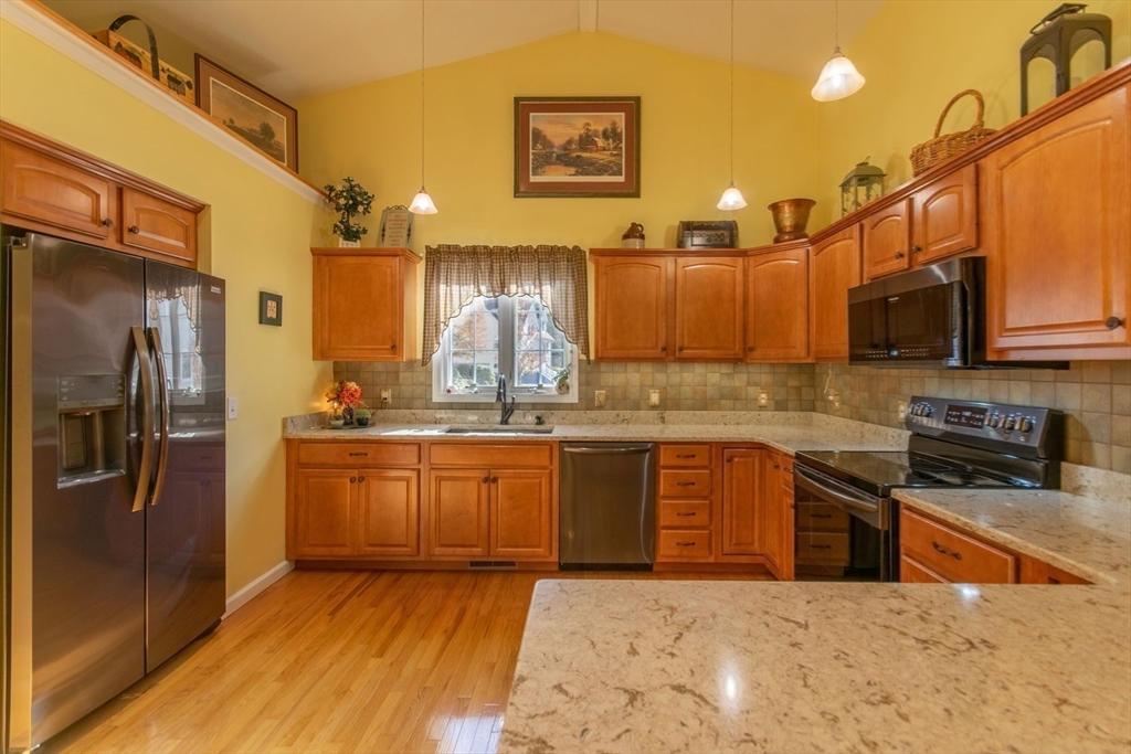 15 Michael Drive, Unit 15 Thorndike, MA 01079 - Photo 14 of 27 a kitchen with stainless steel appliances granite countertop a refrigerator a stove top oven and sink