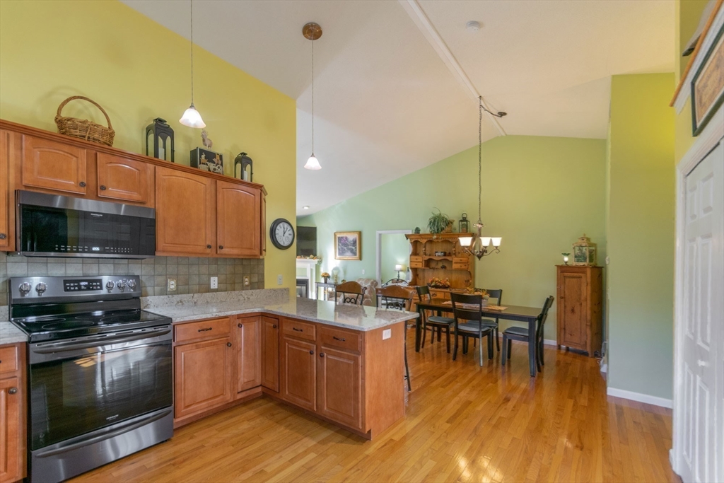 15 Michael Drive, Unit 15 Thorndike, MA 01079 - Photo 9 of 27 a kitchen with a sink cabinets and dining table chairs
