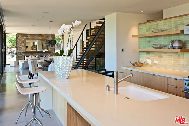 a kitchen with a sink a stove and chairs