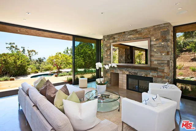 a living room with fireplace furniture and a large window