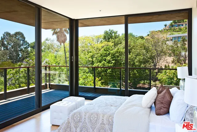 a bedroom with a bed and a large window