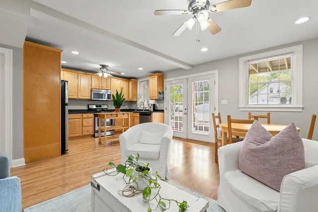 a living room with furniture and a large window with kitchen view
