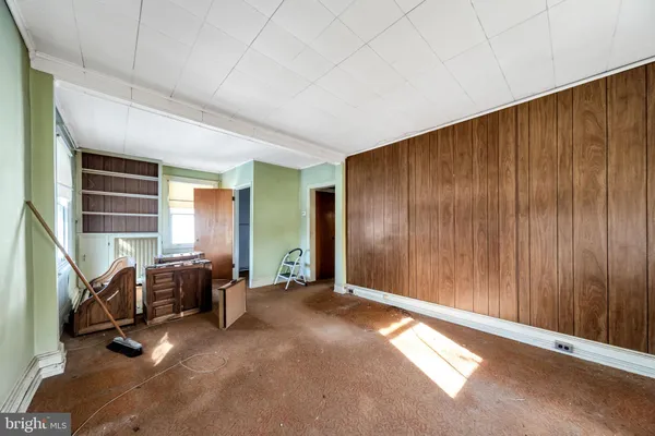 a living room with a bed next to a window