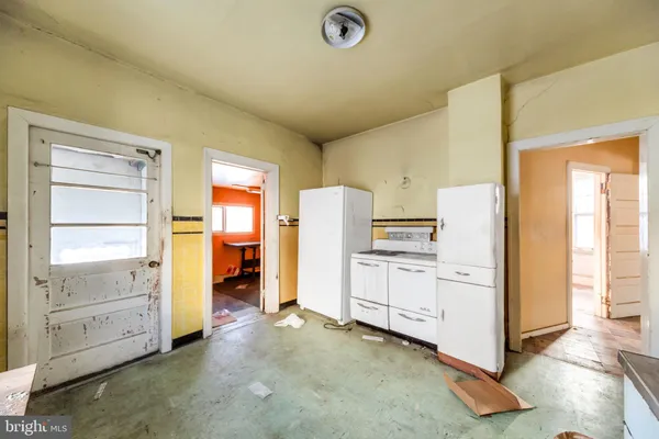 a kitchen with white cabinets and white appliances